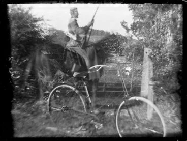 Image: Figure with horse, rifle, and bicycle