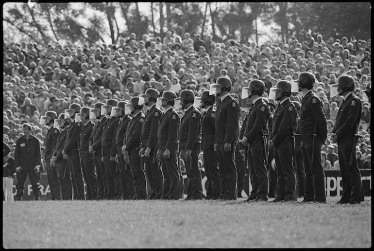 Image: Policemen in riot helmets standing on Rugby Park, Hamilton, during the Springbok rugby tour - Photograph taken by Ian Mackley