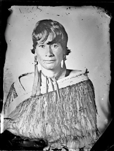 Image: Young Maori woman wearing a pihepehe shoulder cape with pokinikini fringes