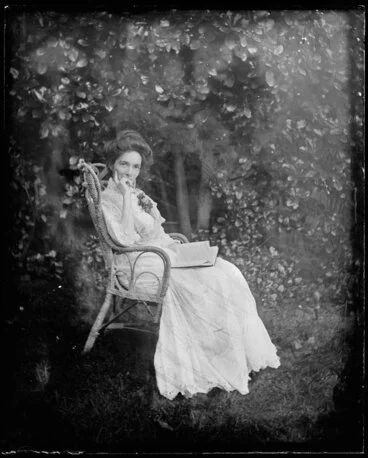 Image: Woman seated in cane chair outdoors