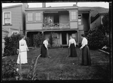 Image: Four women playing croquet in the backyard of a house