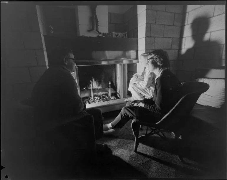 Image: People sitting at open fire, living room, Jim Beard's house, Waikanae, Kapiti Coast