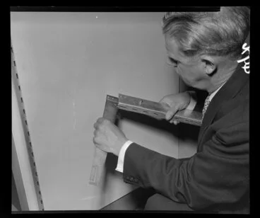 Image: Man demonstrating installation of shop fittings