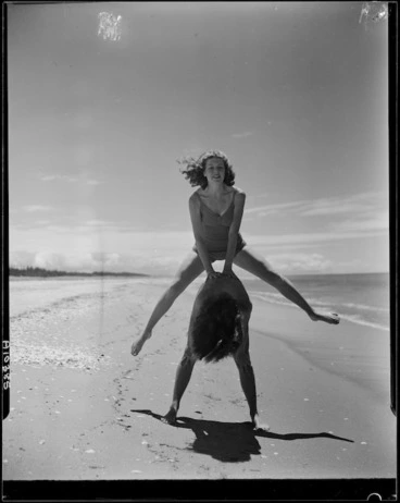Image: Rena Dow and Phyl Belcher playing leapfrog on the sand, Mount Maunganui - Photograph taken by Mr W Walker