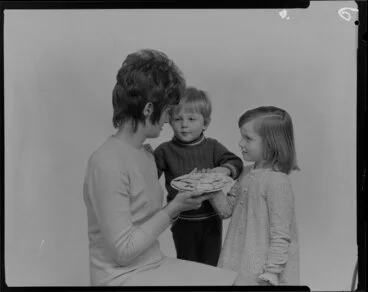 Image: Woman and two children with crackers on a plate