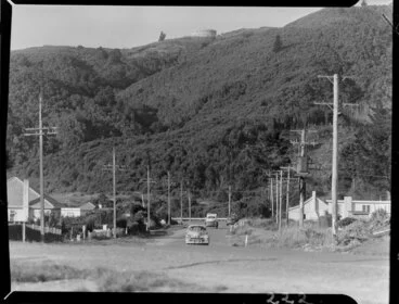 Image: Stokes Valley, Lower Hutt, Wellington Region, including cars on the street and a water reservoir on the bush clad hill above