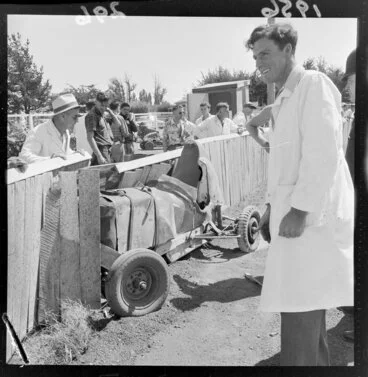 Image: Unidentified men observe a home-made racing car that has crashed at the Masterton Speedway [Queen Elizabeth Park? Solway Show Grounds?], Wairarapa Region