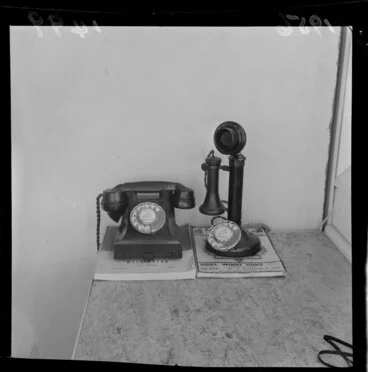 Image: One old and one new telephone on top of telephone directories