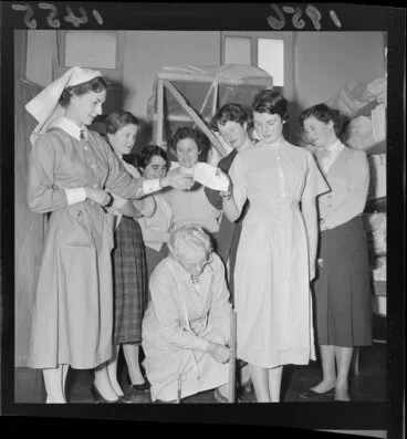 Image: Student nurses watch as a head nurse measures the length of a nurse's uniform at Wellington hospital