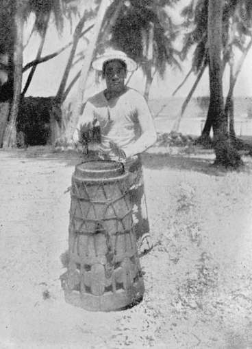 Image: Man playing a village drum for dancing, Manihiki, Cook Islands