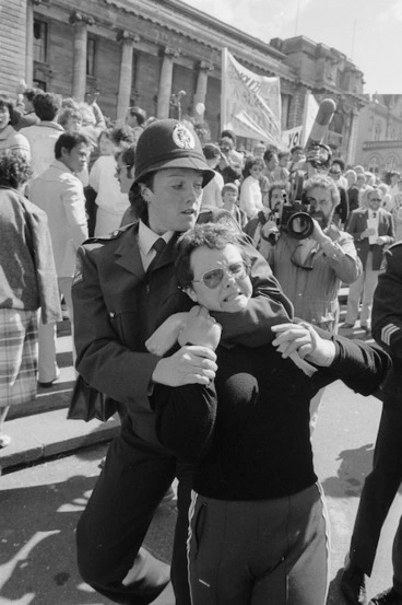 Image: Woman being restrained by a policewoman during demonstration against presentation of a petition opposing the Homosexual Law Reform Bill - Photograph taken by Phil Reid