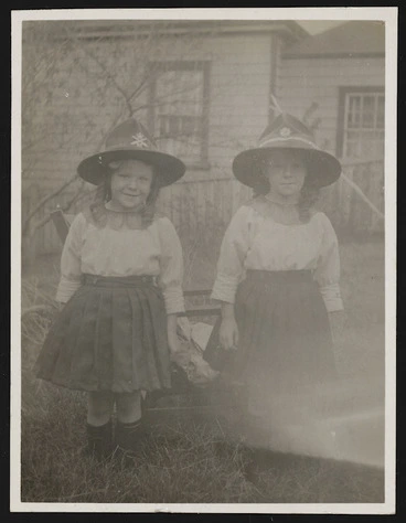 Image: Two young girls wearing World War I servicemen's hats