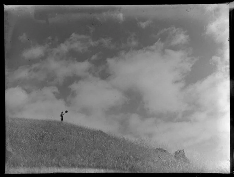 Image: Summer Child Studies series, boy, waving his hat on an hilltop