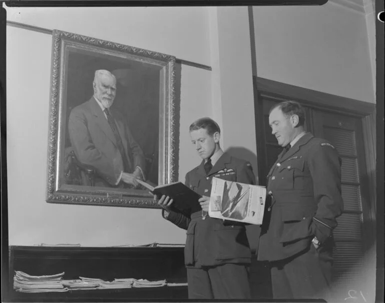 Image: Flight Officers J Phillip and A Levy, Royal New Zealand Air Force, standing in front of a painting of Sir Henry Wigram