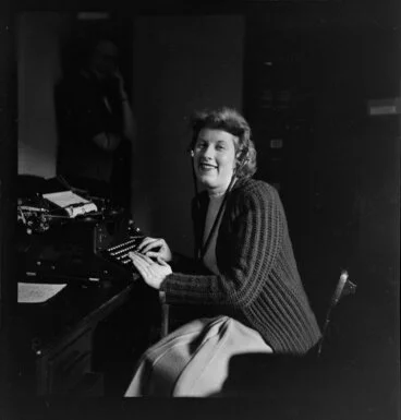 Image: Qantas employee Miss Cullen (Publicity Manager's Office) at typewriter wearing headphones [Qantas headquarters, Mascot, New South Wales?] Australia