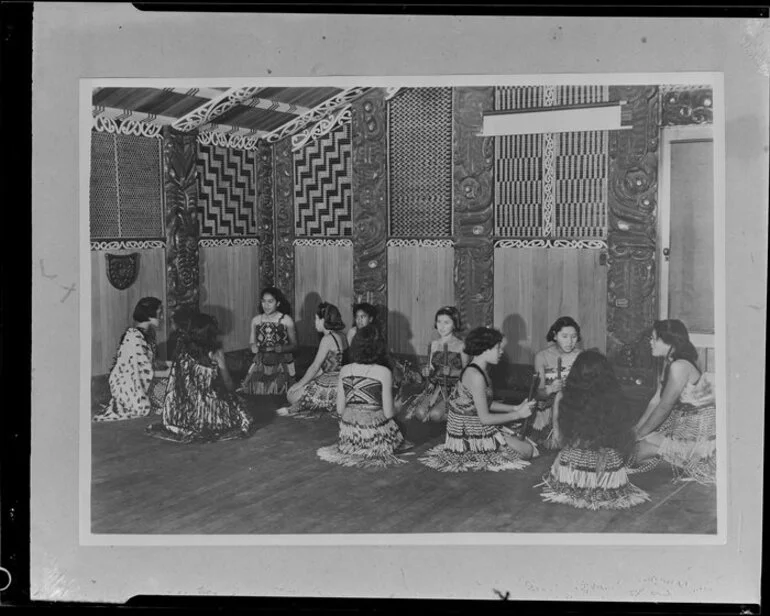 Image: Maori women in traditional costume playing stick games in a meeting house at Rotorua