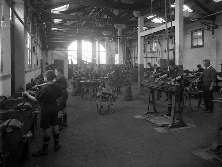 Image: A group of students, all boys, with their tutor during an engineering class at Wanganui Technical College