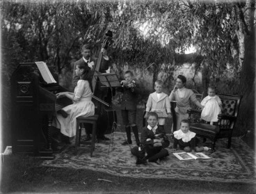 Image: James McAllister and family, outside, with musical instruments