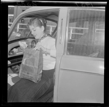 Image: Woman demonstrates a litter bag in the passenger seat of a car [Austin?]