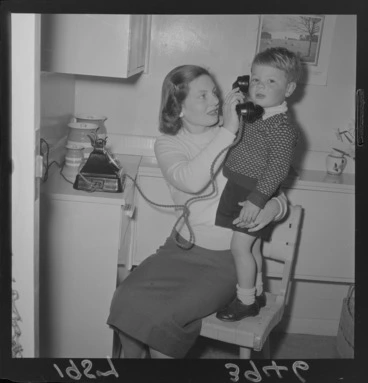 Image: Unidentified young boy and his mother with a new telephone in their kitchen, Wellington
