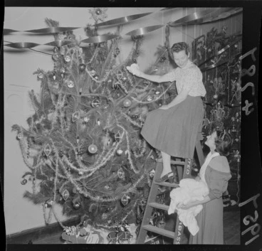 Image: Two young women, decorating a Christmas Tree