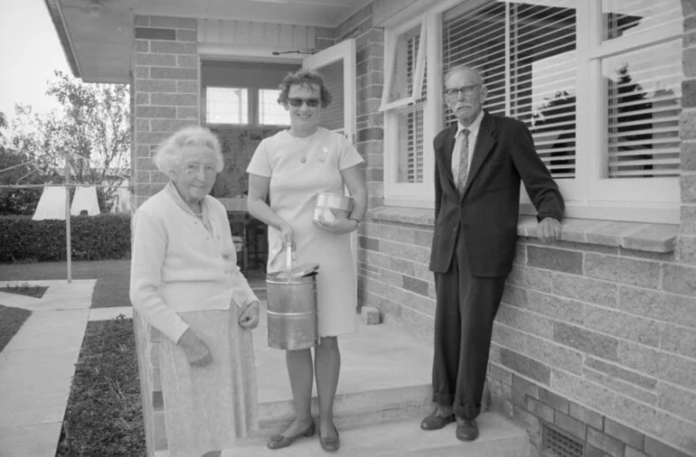 Image: Meals on Wheels woman delivering food to a couple