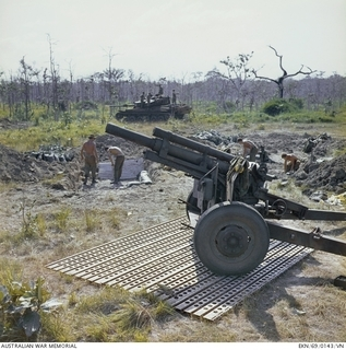 Image: May Tao, South Vietnam. 2 December 1969. A 105mm howitzer gun of 101st Battery, Royal Australian Artillery, stands ready for instant action on steel mesh matting in support of 6RAR /NZ (ANZAC) (The ..