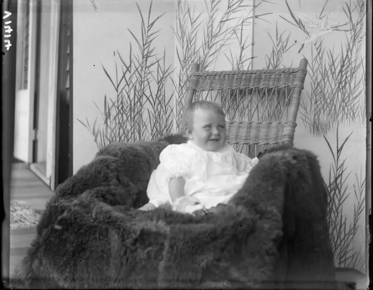 Dolly Vaile seated in a fur rug, 1910