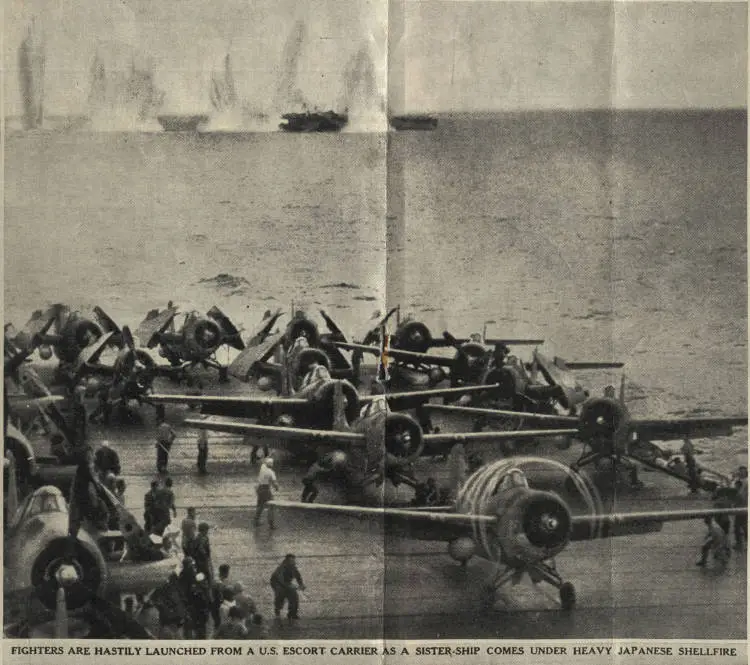 Fighters are hastily launched from a U. S. escort carrier as a sister-ship comes under heavy Japanese shellfire