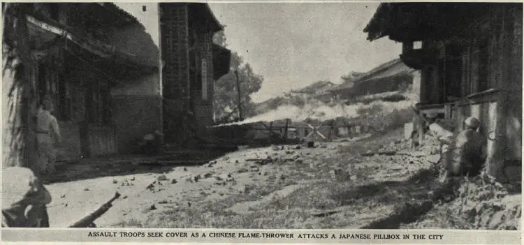 Assault troops seek cover as a Chinese flame-thrower attacks a Japanese pillbox in the city