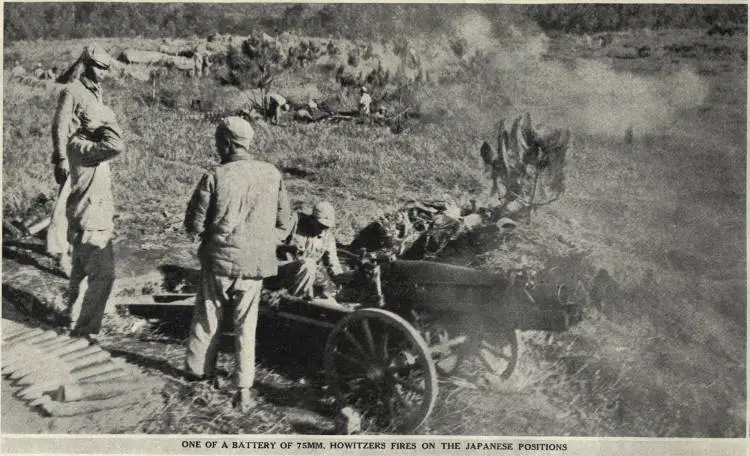 One of a battery of 75mm. howitzers fires on the Japanese positions