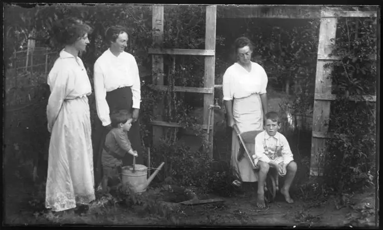 Women and young boys in a garden