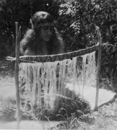 Māori woman weaving taniko