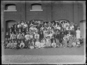 Large unidentified group, in front of a brick building, probably Christchurch district