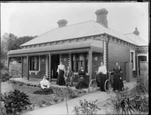 Unidentified family group, outside their home, probably Christchurch district, includes two women with bicycles