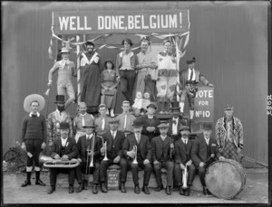 Group of unidentified entertainers, including clowns and musicians, probably Christchurch district, including signs saying 'Well done, Belgium', 'Vote for No.10', 'Muny box for the Belguns'