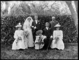 Unidentified wedding group outdoors, showing bride and groom, groomsman, bridesmaid, flowergirls [and father of bride?], probably Christchurch district