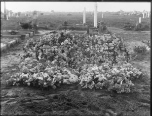Unidentified cemetery, probably Christchurch district, showing flowers laid on dirt and other gravesites in the background
