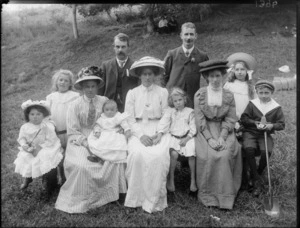 Family group, showing unidentified men, women and children, including a boy holding a spade, in a park, possibly Christchurch district