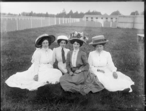 Four unidentified women sitting on the grass at a racecourse, probably Christchurch district