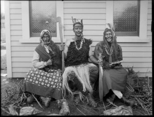 Three unidentified people dressed in costume as Maori women and a man, at the back of the house, possibly Christchurch district