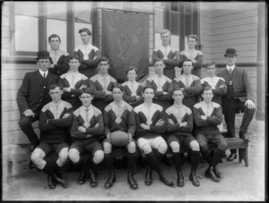 Unidentified members of the Christchurch Rugby [Union?] team, showing a banner in the background with [Marist Brothers Old Boys Association?] MBOBA, CHRISTCHURCH on it, outside the hall on Barbadoes Street, Christchurch