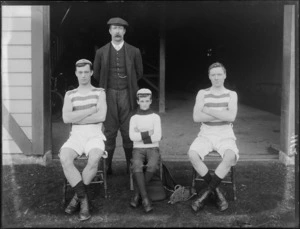 Unidentified rowers, coxman and coach in front of the shed, possibly Christchurch district