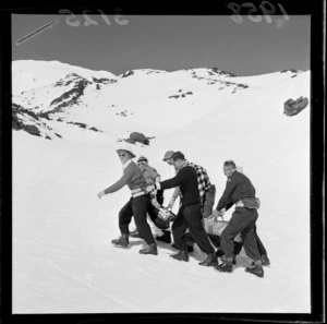 Group of St John staff and others carrying an injured skier at the New Zealand Ski Championship, Mt Ruapehu