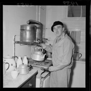 Unidentified man putting on the kettle in the kitchen of the new premises of the Repertory Theatre, The Terrace, Wellington