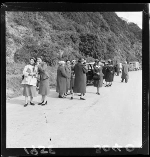 A group of women out of their cars waiting for a slip to be cleared off the road at Point Howard, Lower hutt