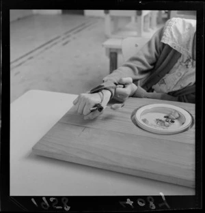 A student eating lunch with the assistance of a mechanic aid to hold cutlery, at Kimi Ora School for children with special needs, Thorndon, Wellington