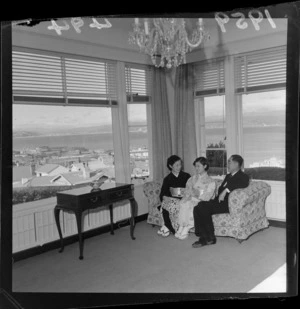 Interior of the official residence of the Japanese Ambassador in Wellington with unidentified Japanese women and a man sitting on a couch