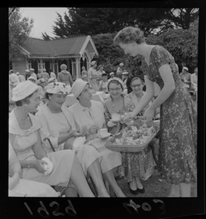 Unidentified guests being served tea and cakes in the garden at a fashion show at Homewood, Karori, Wellington
