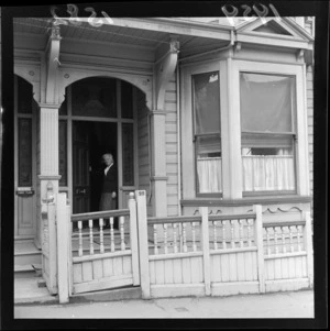 Dame Elizabeth Knox Gilmer standing in the doorway of her home at 22 Boulcott Street, Wellington
